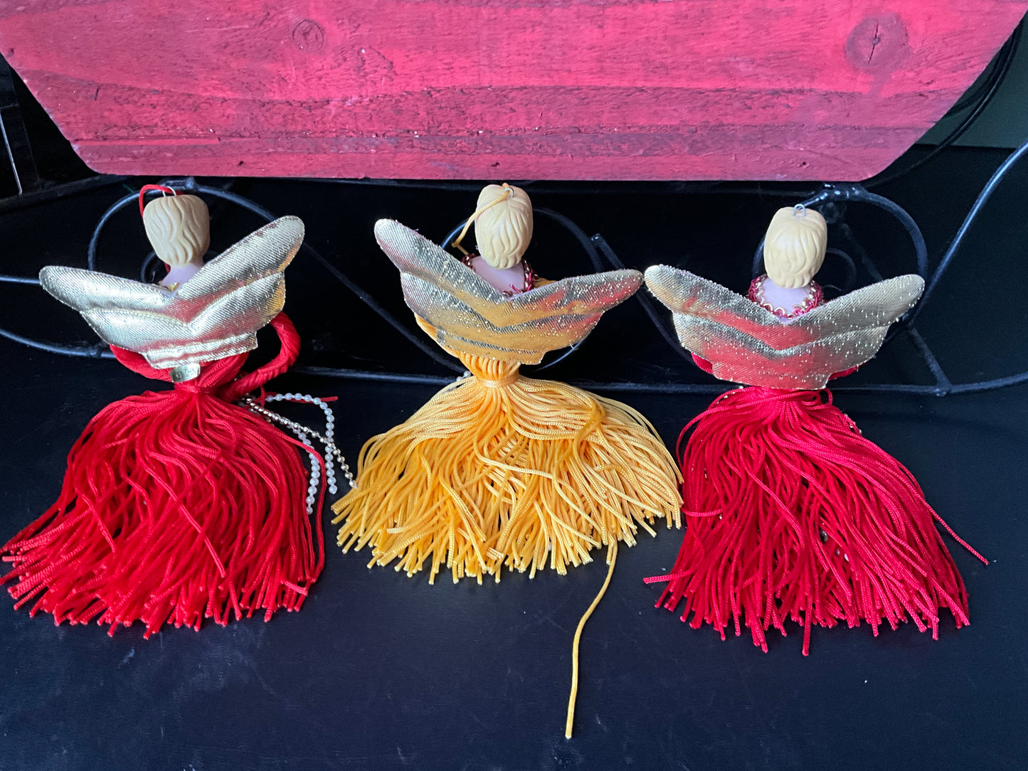 A trio of terrific tassel angels with porcelain heads gold family wings and floss bodies