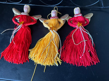 A trio of terrific tassel angels with porcelain heads gold family wings and floss bodies