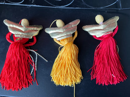 A trio of terrific tassel angels with porcelain heads gold family wings and floss bodies