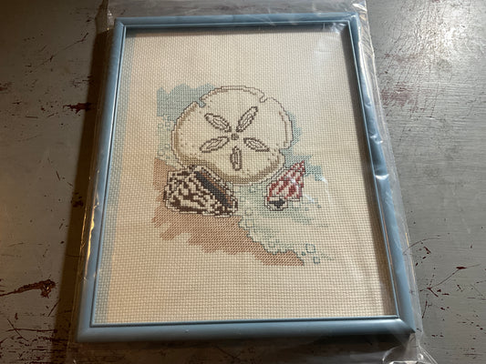 Tranquil beach with sand dollar and seashells cross stitch picture finished project in blue frame