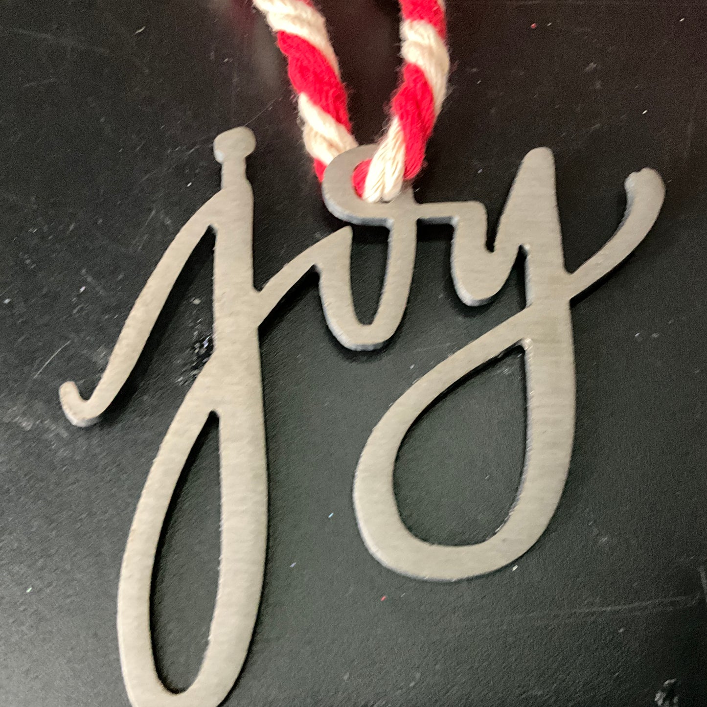 JOY lazer cut steel cutout Christmas ornament on a rope