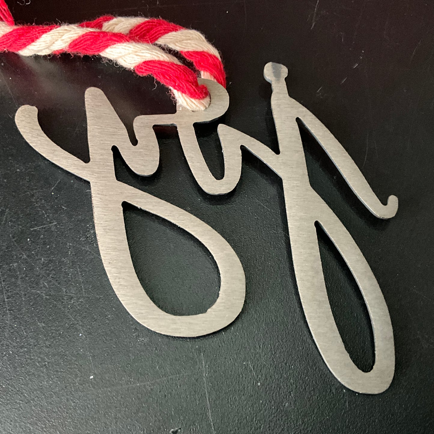 JOY lazer cut steel cutout Christmas ornament on a rope