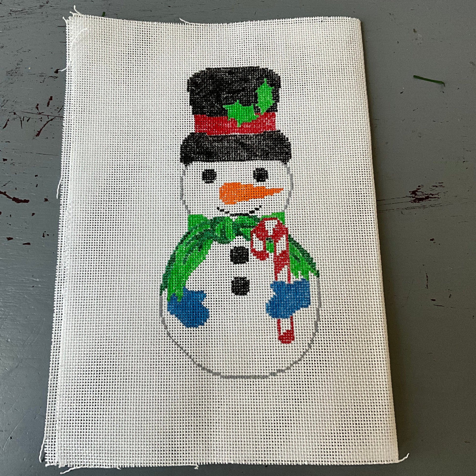 Snowman in top hat and scarf holding a candy cane front & back needlepoint canvas 6 by 3 inches