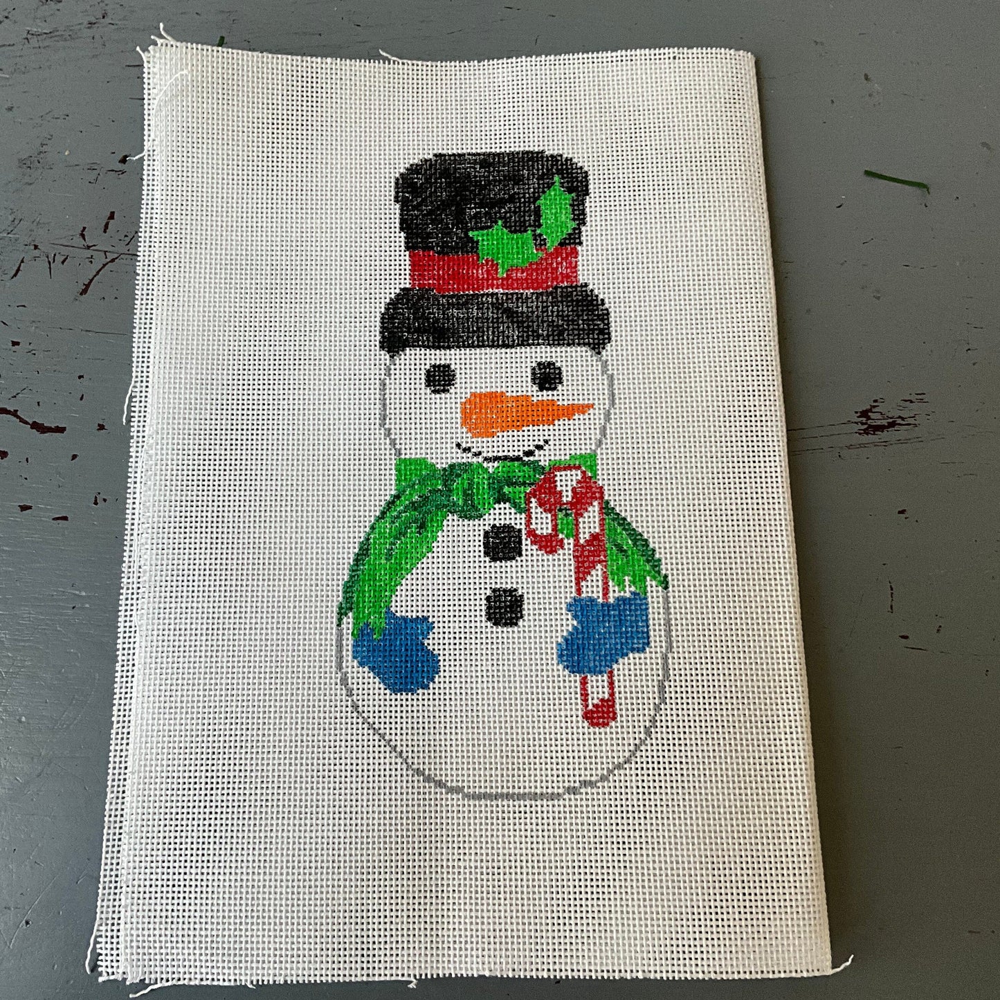 Snowman in top hat and scarf holding a candy cane front & back needlepoint canvas 6 by 3 inches