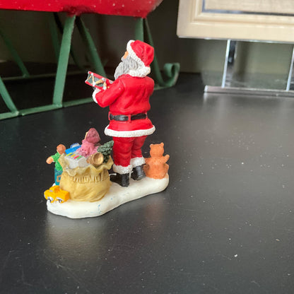 Lemax Santa Claus holding a little toy drum next to his sack of toys collectible figurine