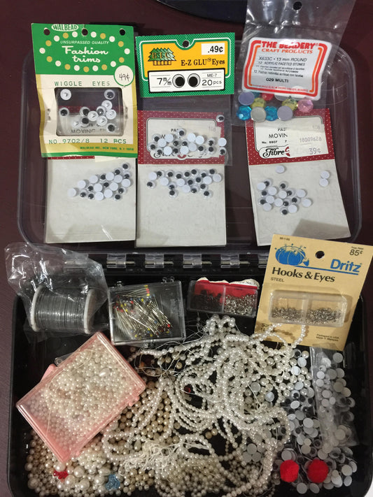 Beady looking eyes and pearly looking beads even hooks and eyes in a great durable project container