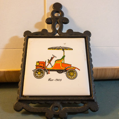 Cast Iron and Tile, 1905 Reo Automobile Trivet,Made in Japan, 3 by 3 inch tile, 6.5  tall by 3.5 wide Inches